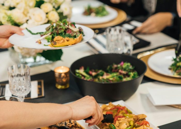 A sophisticated dining setup with vibrant dishes being shared among friends at a gathering.